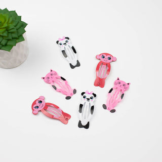Set of animal-shaped hair clips on a white background with a small plant.