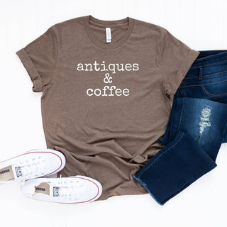 Brown t-shirt with 'antiques & coffee' text, white sneakers, and blue jeans on a white background
