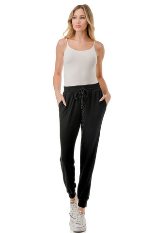 Woman wearing a white tank top and black jogger pants on a white background - JSQ Mercantile - womens boutique and gift shop in La Grange, IL 
