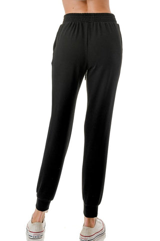 Woman wearing a white tank top and black jogger pants on a white background - JSQ Mercantile - womens boutique and gift shop in La Grange, IL 