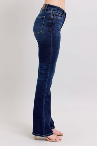 Dark blue jeans worn by a person on a light gray background