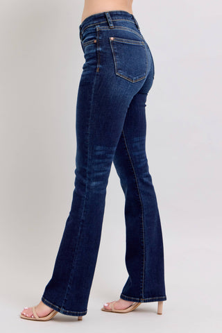 Blue jeans worn by a person on a plain background