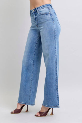 Blue jeans worn by a person on a plain background