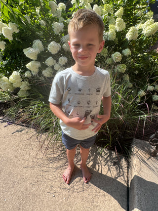 Child standing outdoors near flowers and plants