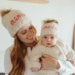 Mini Embroidered Toddler Hat with Brown Pom Pom – Hand-knit baby hat with “Mini” in cerise pink yarn. Sustainable and gift-ready. Available at JSQ Mercantile in La Grange, IL.