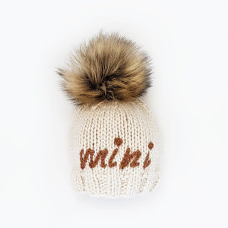 Mini Me Peanut Beanie Hat – Neutral hand-knit baby hat with “Mini” embroidery and brown pom pom. Eco-friendly and gift-ready. Available at JSQ Mercantile in La Grange, IL.