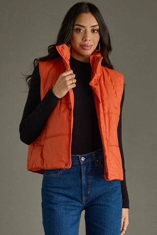 Rust Puffer Vest with zipper + snap closure, pockets, and adjustable hemline. Perfect for layering. Shop JSQ Mercantile La Grange, IL.