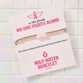 Holy Water Pink Ribbon Awareness Bracelet with waterproof beads and pink ribbon charm infused with holy water from Lourdes, France | JSQ Mercantile – Women’s Boutique & Gift Shop in La Grange, IL