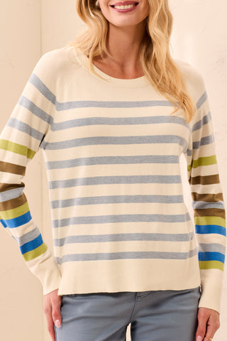 A woman wearing a striped sweater with a crew neck and long sleeves in moonstone with multicolor stripes.